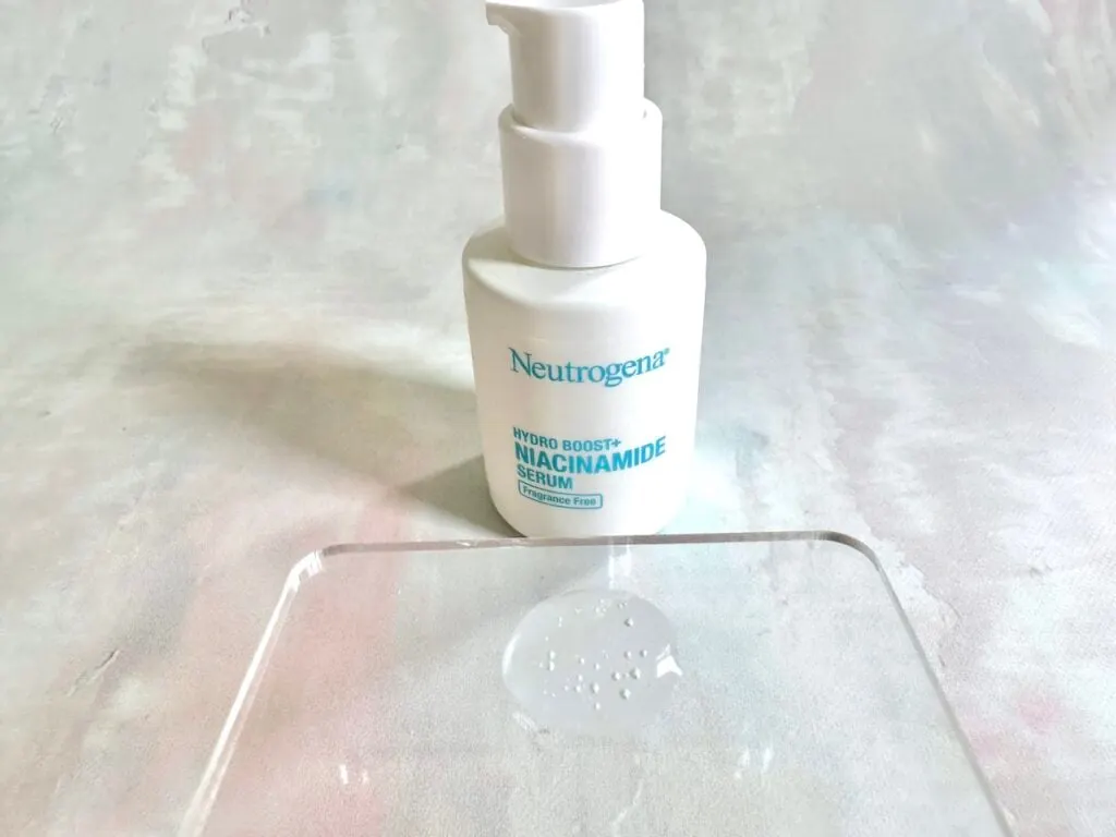 Neutrogena Hydro Boost+ Niacinamide Serum, bottle and sample on clear spatula.