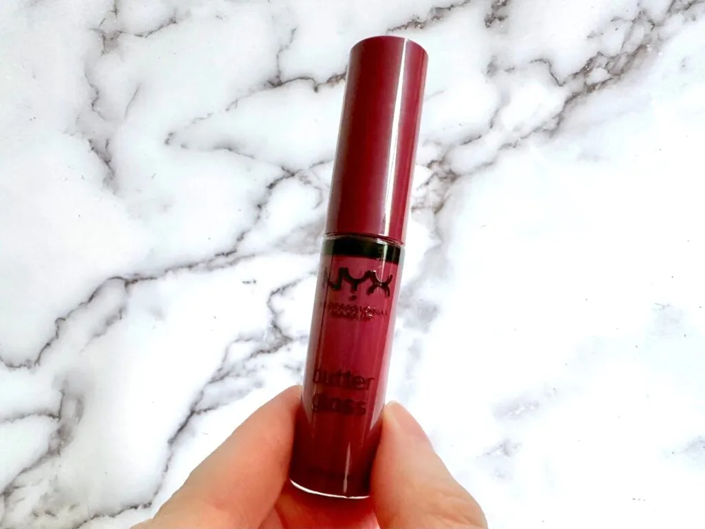 NYX Butter Gloss in the shade Cranberry Pie, handheld.