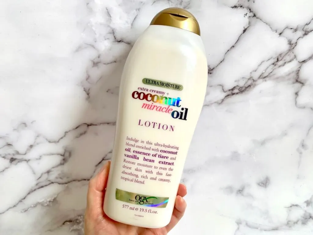 OGX Extra Creamy Coconut Miracle Oil Ultra Moisture Lotion handheld.