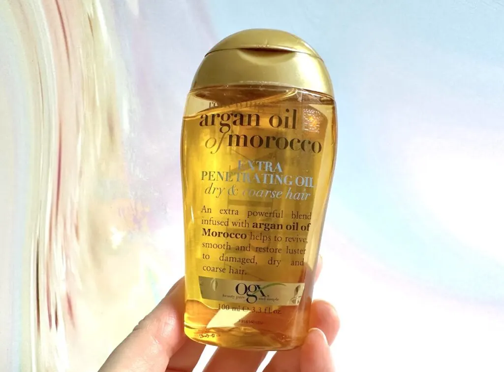 OGX Extra Strength Renewing + Argan Oil of Morocco Hair Oil, handheld.