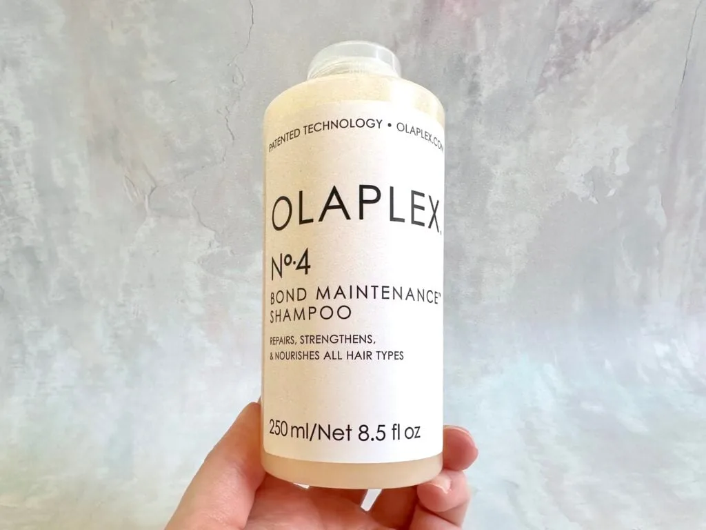 Olaplex No. 4 Bond Maintenance Shampoo, handheld.