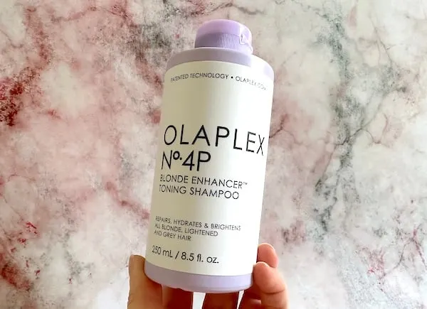 Olaplex No.4P Blonde Enhancer Toning Shampoo handheld.