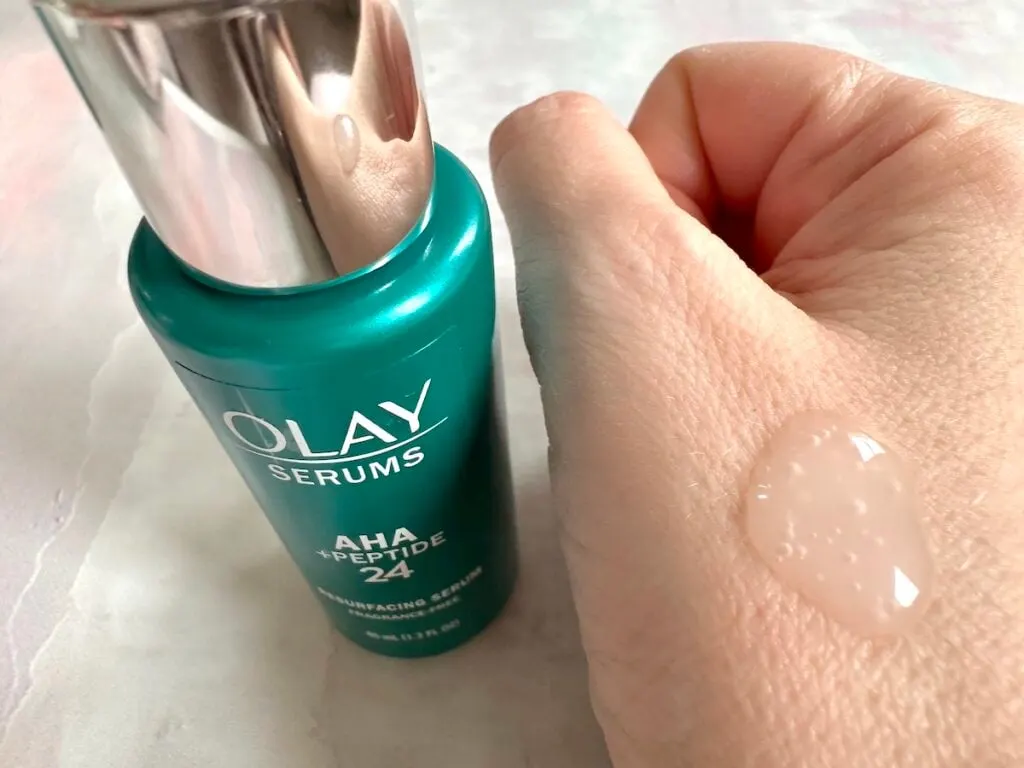 Olay AHA + Peptide 24 Serum, bottle next to sample on hand.