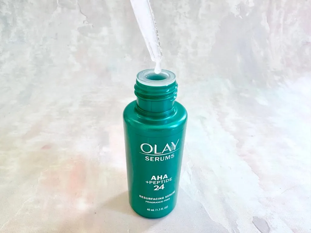 Olay AHA + Peptide 24 Serum, open bottle with dropper.