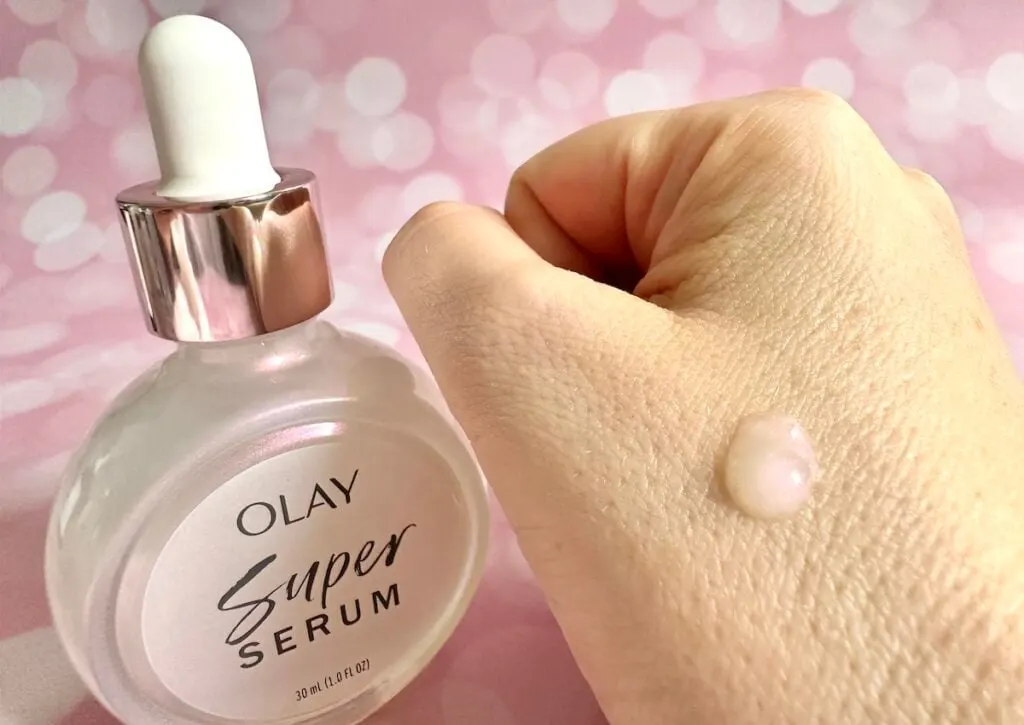 Olay Super Serum, bottle next to sample on hand.