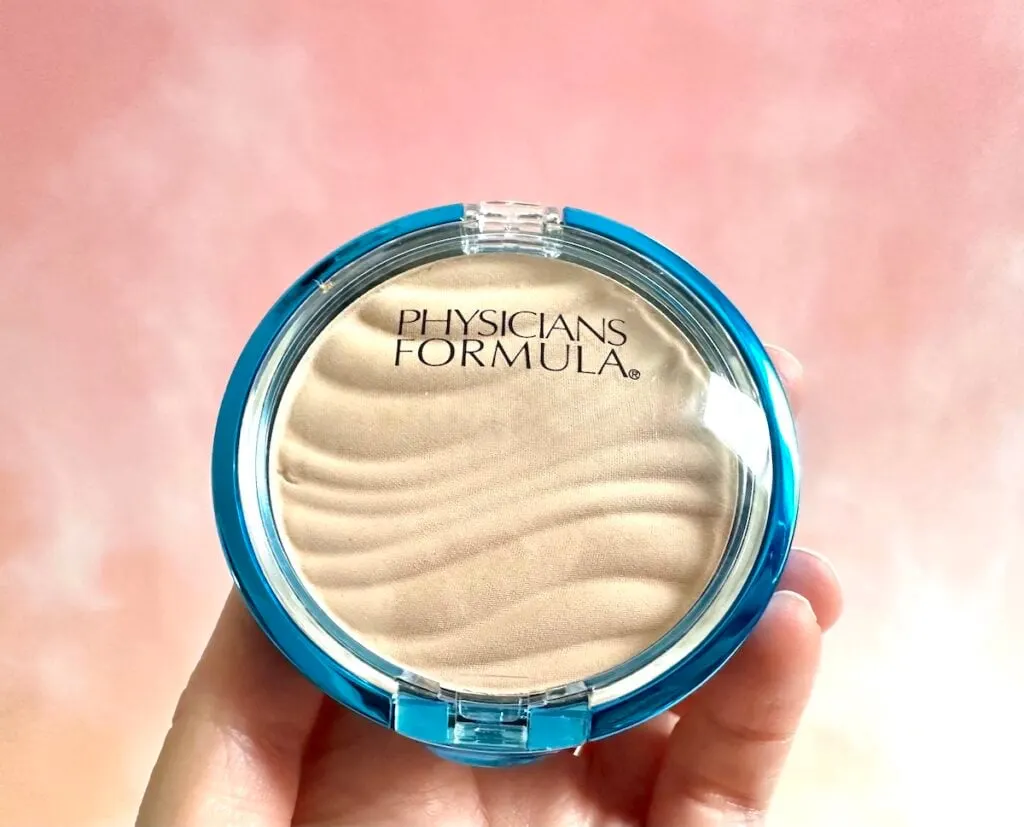 Physicians Formula Mineral Wear Talc-Free Mineral Airbrushing Pressed Powder SPF 30 in the shade Translucent, handheld.