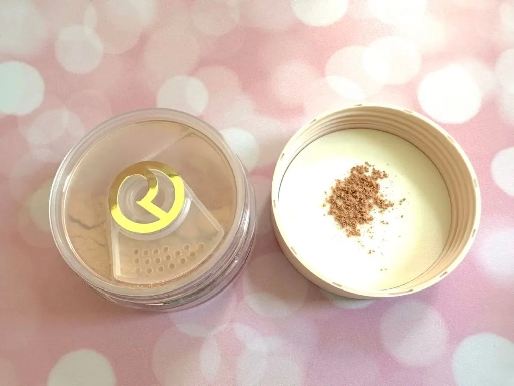 Rare Beauty Always an Optimist Soft Radiance Setting Powder in the shade Light-Medium, open jar with sample on inside of lid.