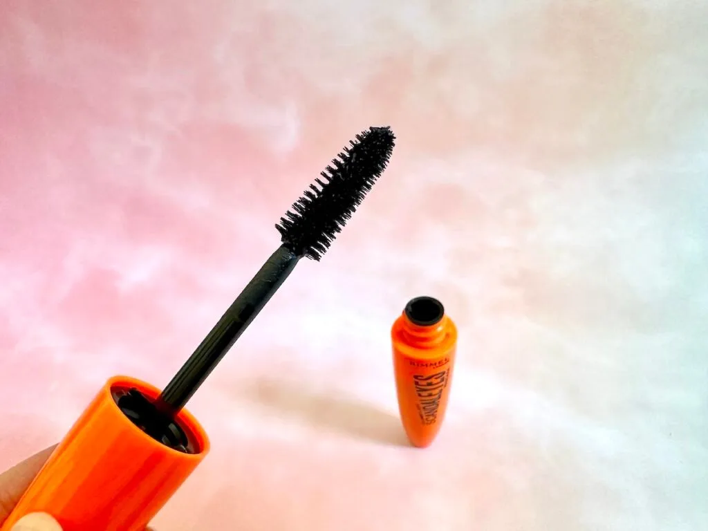 Rimmel Scandaleyes Mascara wand and open tube in background.