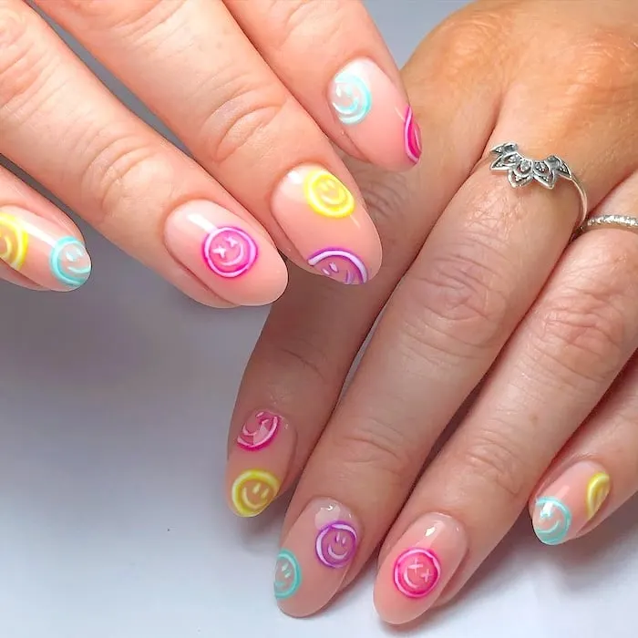 Pastel smiley face nails.