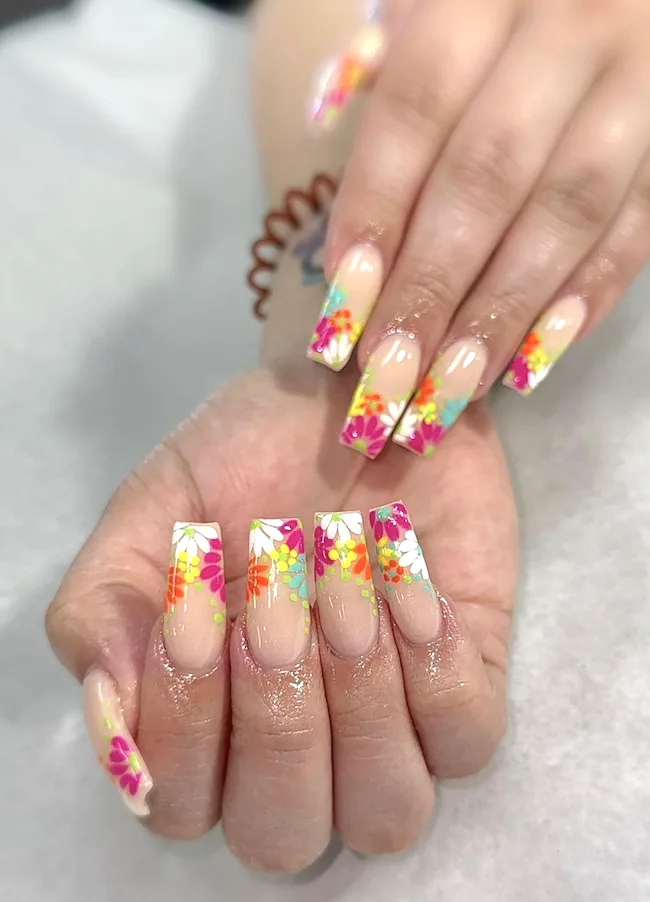 Bright floral French tip nails.