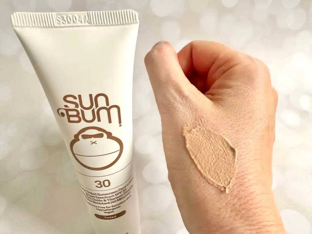 Sun Bum Mineral SPF 30 Tinted Sunscreen tube next to sample on hand.