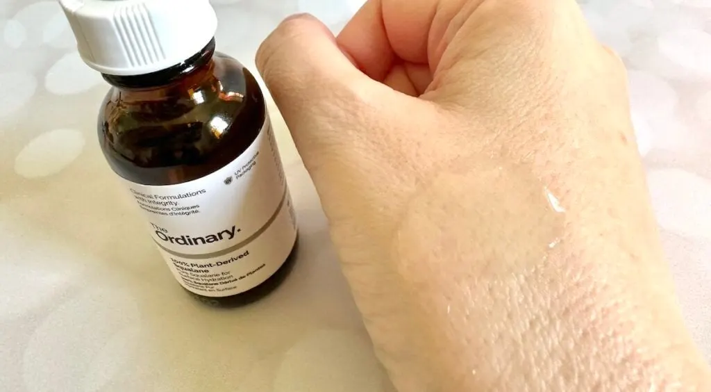 The Ordinary 100% Plant-Derived Squalane, bottle next to sample on hand.