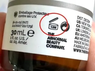 The Ordinary Expiration Dates: PAO Symbol of 12M circled in red on side of The Ordinary bottle, handheld.