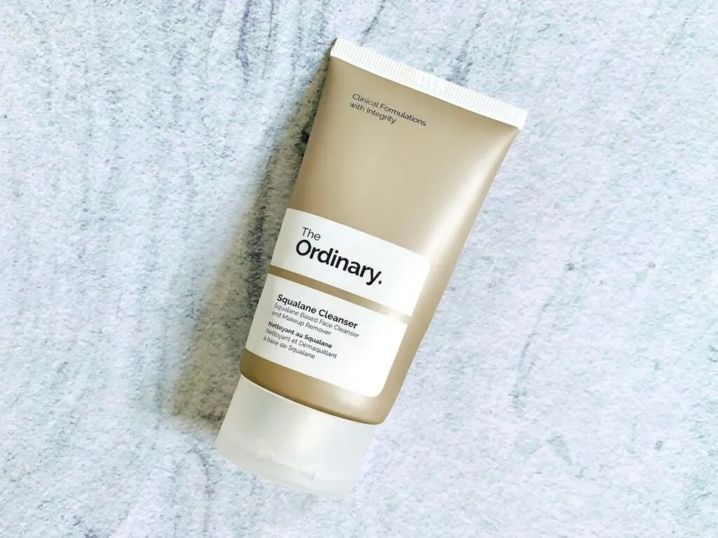 The Ordinary Squalane Cleanser flatlay on a blue background.