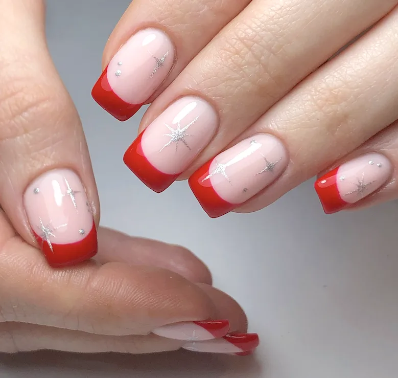 Red French tip nails with silver stars.