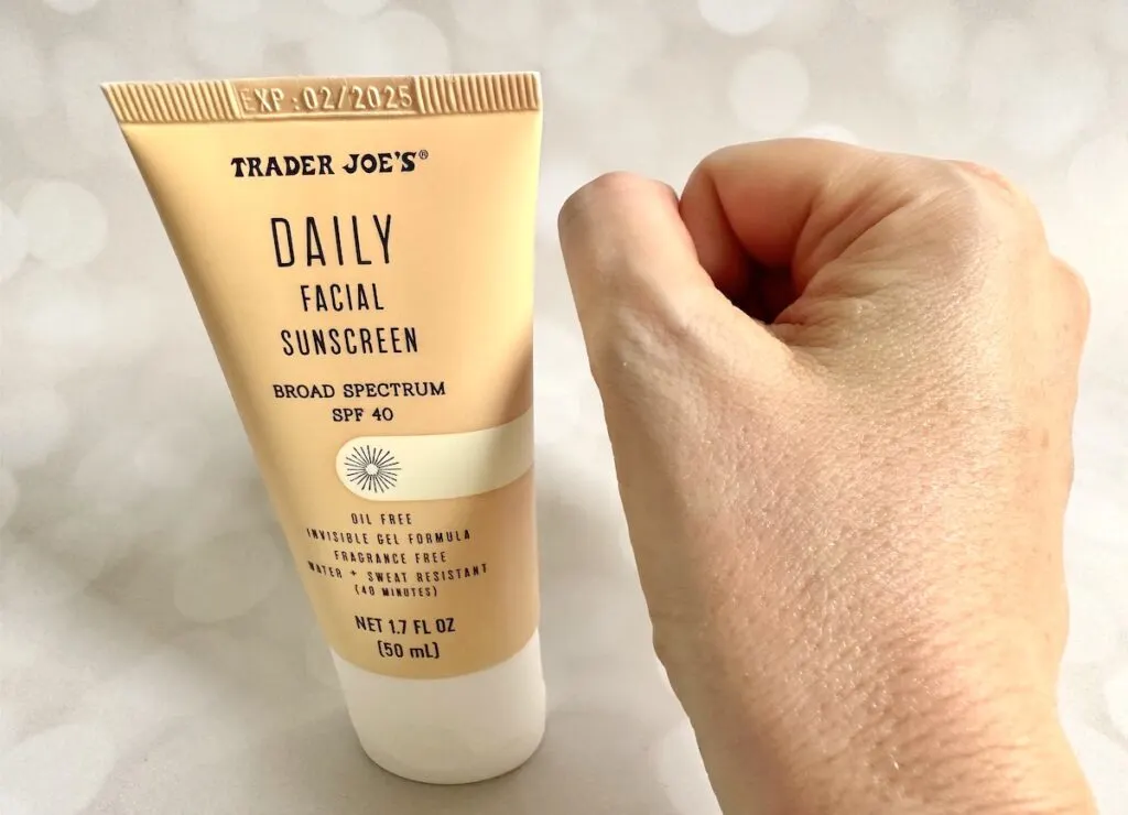 Trader Joe's Daily Facial Sunscreen Broad Spectrum SPF 40 tube next to sample absorbed on hand.