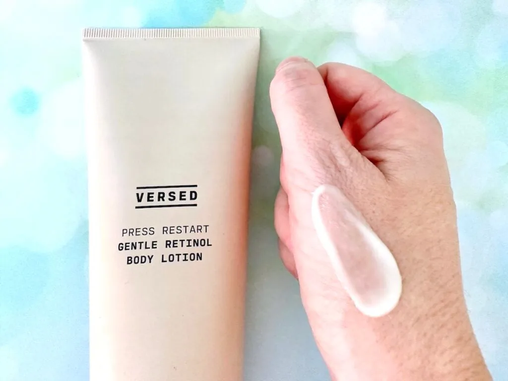 Versed Press Restart Gentle Retinol Body Lotion, flatlay next to sample on hand.