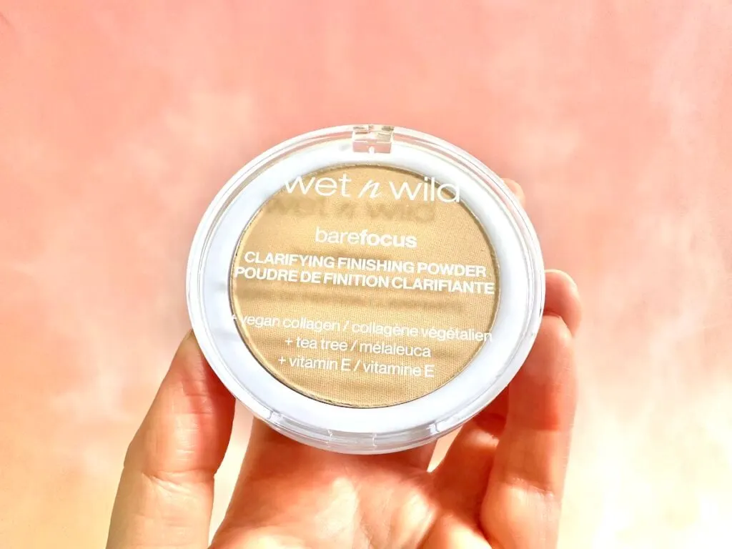 Wet n Wild Bare Focus Clarifying Finishing Powder in the shade Light/Medium, handheld.